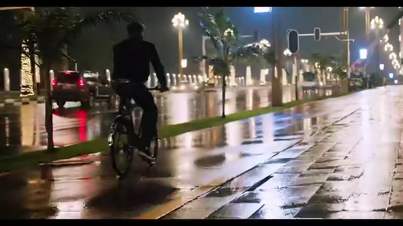 A cyclist on a wet, brightly lit street on a rainy night in Addis Ababa