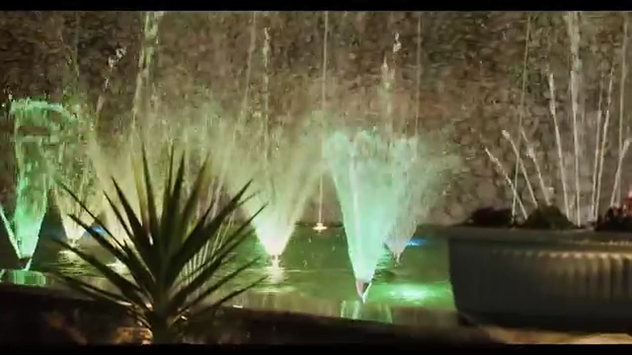 Green-lit fountains in an Addis Ababa park at night